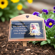 Memorial plaque in a garden setting with flowers.