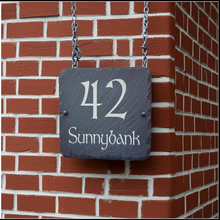 Slate house number sign with '42 Sunnybank' on a brick wall