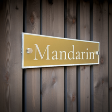 Gold sign with 'Mandarin' text on a wooden background. Modern and stands out as stylish.