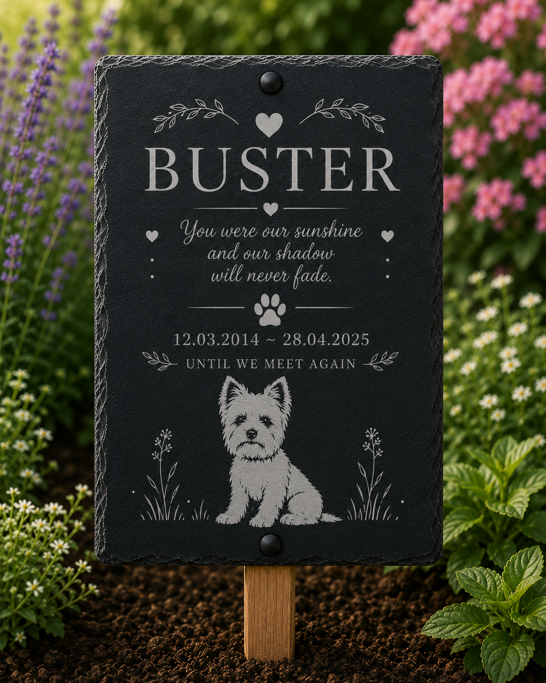 A personalized black slate pet memorial garden sign with engraved white text and a white dog illustration, mounted on a wooden stake in a garden setting.