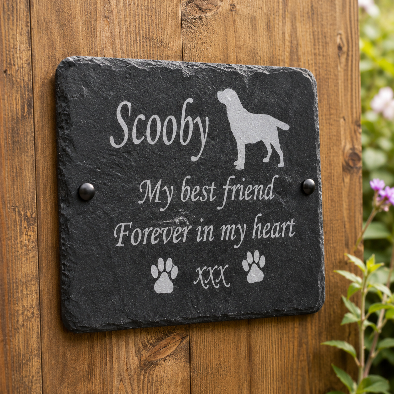 Personalized black slate memorial plaque mounted on a wooden wall, engraved with the name 'Scooby', a dog silhouette, the phrase 'My best friend Forever in my heart', and paw prints.