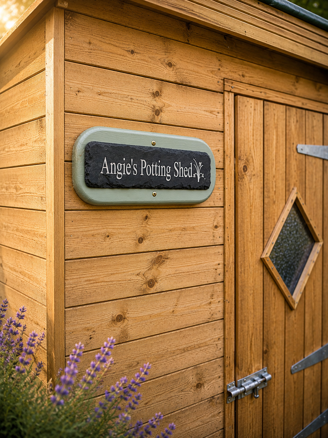 Close-up of a wooden potting shed exterior with a sign reading 'Angie's Potting Shed' mounted on the wood panel wall beside a wooden door with a diamond-shaped window.