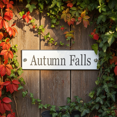 Wooden door with 'Autumn Falls' sign surrounded by autumn leaves