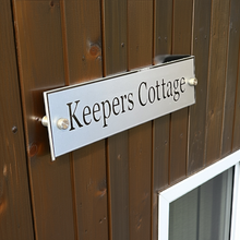 Wooden door with 'Keepers Cottage' sign