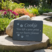 Memorial plaque for a pet named Cookie on a rock in a garden setting