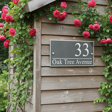 Wooden shed with pink roses and a house number sign reading '33 Oak Tree Avenue'.