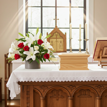 Floral arrangement on an altar in a church setting with ashes casket