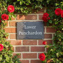 slate sign on a brick wall with personalised lettering