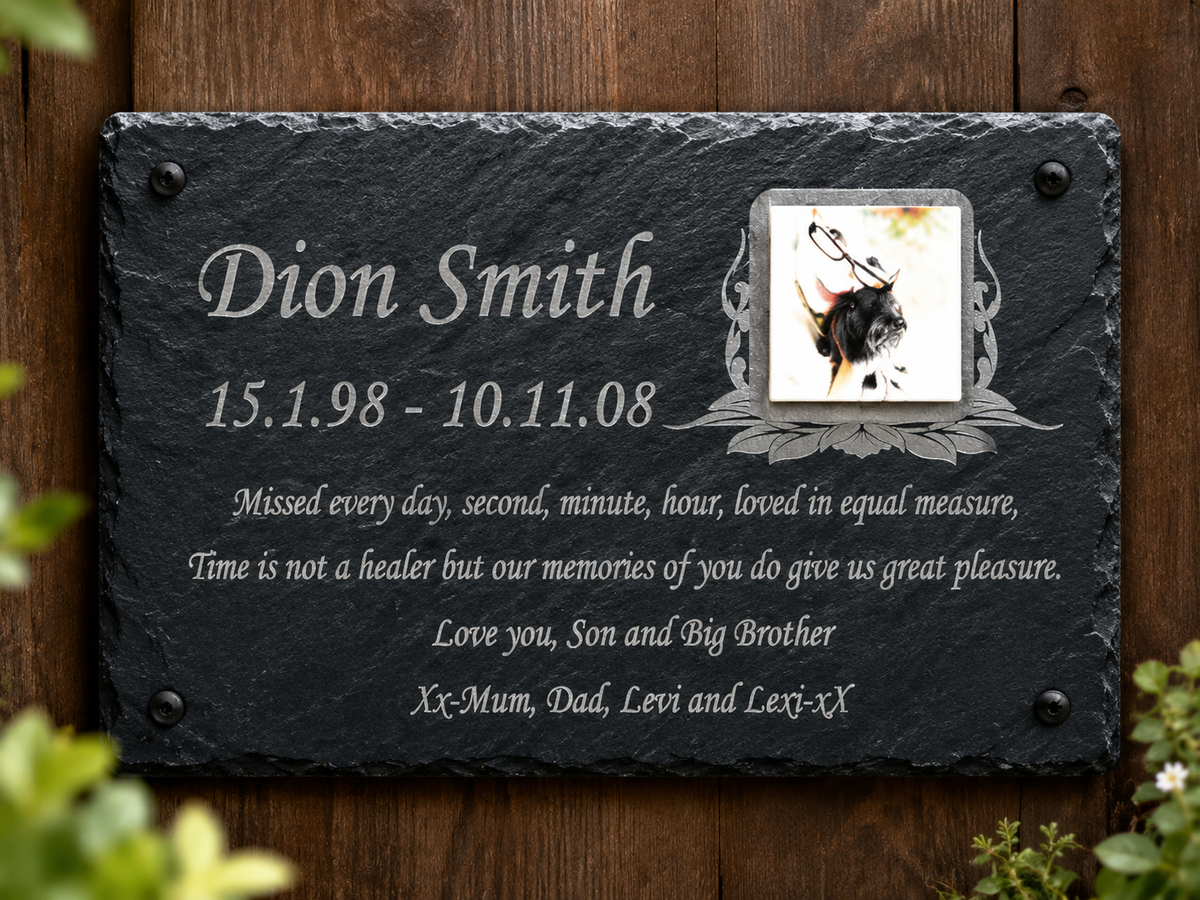Personalized black slate memorial plaque mounted on a wooden wall, engraved with the name Dion Smith, dates, a small bison illustration, and a memorial quote.