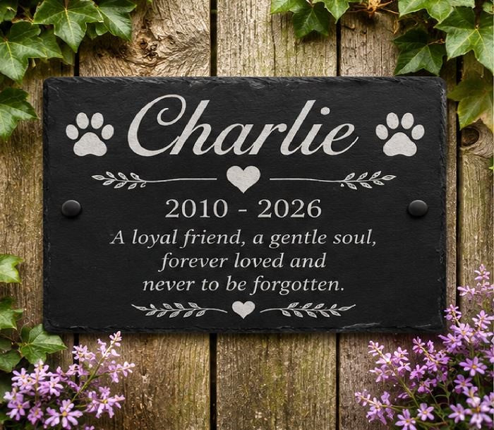 Memorial plaque for a pet named Charlie with a wooden background and flowers.