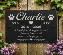Memorial plaque for a pet named Charlie with a wooden background and flowers.