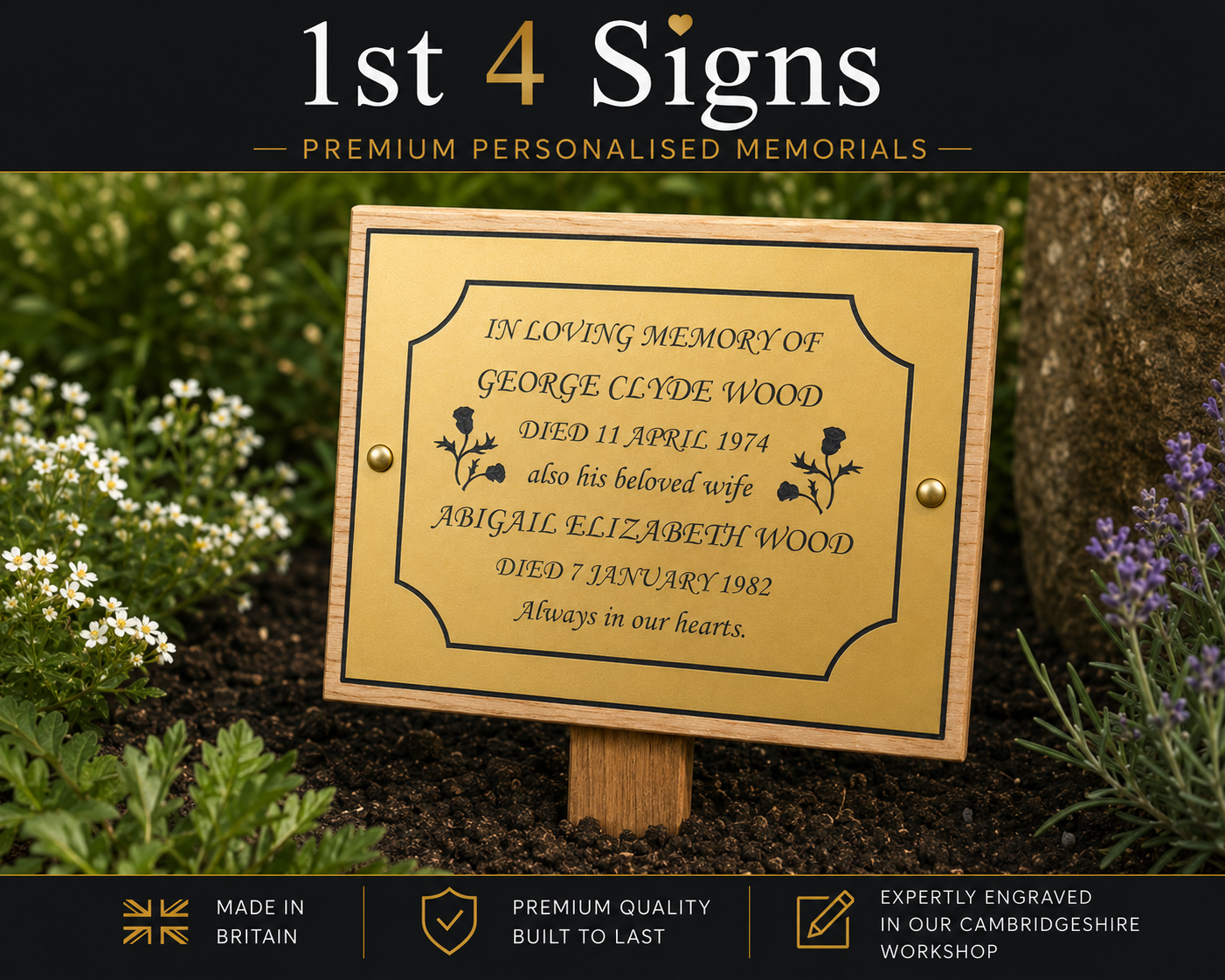 A personalized brass memorial plaque mounted on a wooden stake, displayed outdoors in a garden bed with green foliage and small white flowers. The plaque features engraved text for George Clyde Wood's memory with dates and the name of his wife Abigail Elizabeth Wood.